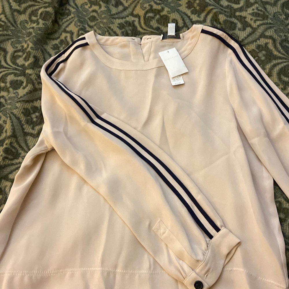Blouse with piping along arm and covered button.
